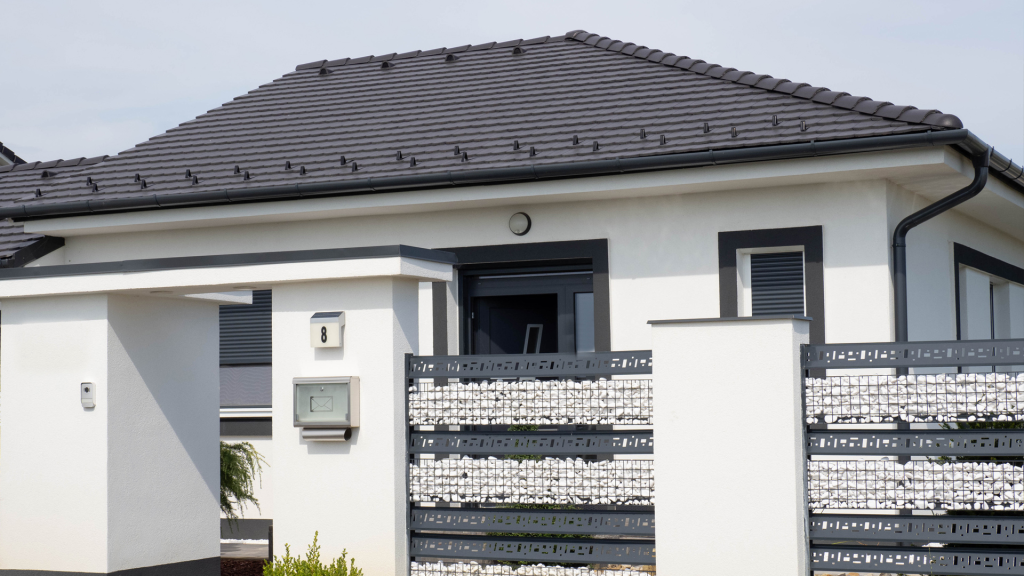 Rundo Carbon Tetőcserép szürke-fehér designnal, kaviccsal készült kerítéssel. Rundo Carbon Tetőcserép fehérszínű házon.