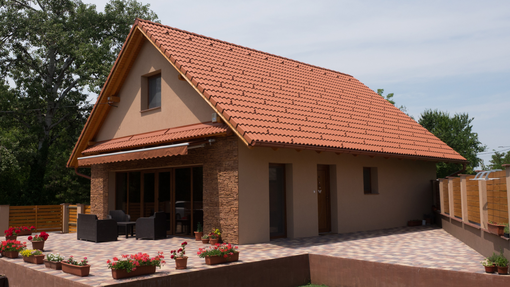 Téglaszínű Renova Tetőcserép terrakotta térkővel burkolt terasszal. Téglaszínű Renova tetőcserép muskátlikkal a teraszon.